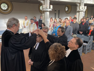 Pfarrer Holm Haschker (Mitte) wird beim Einführungsgottesdienst in der Stadtpfarrkirche durchn (v.l.n.r) Dekan Jochen Wilde und den vier Assisten*innen Pfarrer Jakob Sibbor, Zwillingsbruder Dirk Haschker, Pfarrer Stephan Schmoll und Militärseelsorgerin Claudia Brunnmeier-Müller gesegnet.